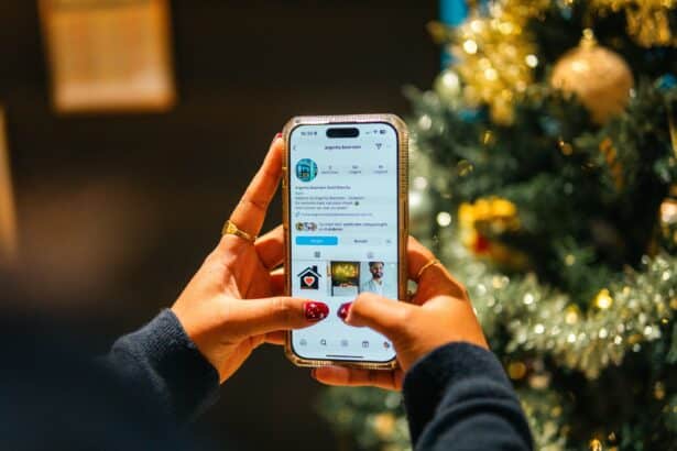 Main tenant un smartphone affichant un profil Instagram, devant un sapin de Noël décoré.