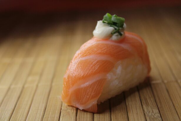 Sushi saumon sur natte de bambou, garni d'oignon vert et mayonnaise, évoque pourquoi les chats mordent par curiosité alimentaire.