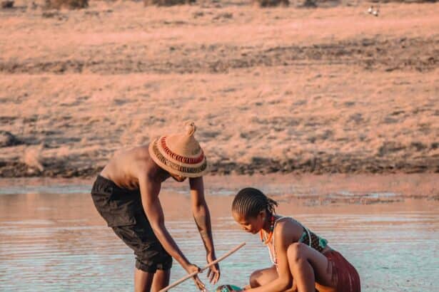 Deux personnes puisent de l'eau dans un lac peu profond, illustrant pourquoi les chats ont peur de l'eau en raison de l'humidité.