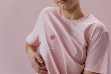 Personne en t-shirt rose avec un dessin de sein stylisé, symbolisant la lutte contre le cancer.