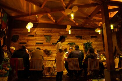Des convives dînent dans un restaurant en bois, éclairé chaleureusement, évoquant pourquoi les chats se cachent pour mourir.