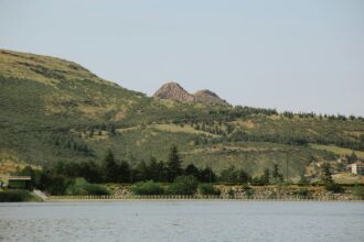 Paysage de montagnes verdoyantes et lac paisible, illustrant la tranquillité. Pourquoi les chats se roulent par terre reste un mystère.